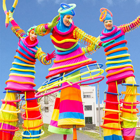 Malabaristas de zancos de rosquillas de colores